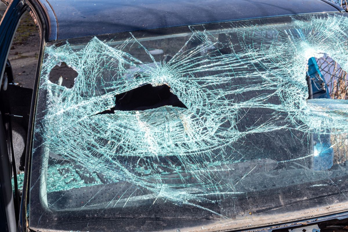 Severely shattered and vandalized windshield on a car, highlighting the need for professional replacement by Affordable Auto Glass.