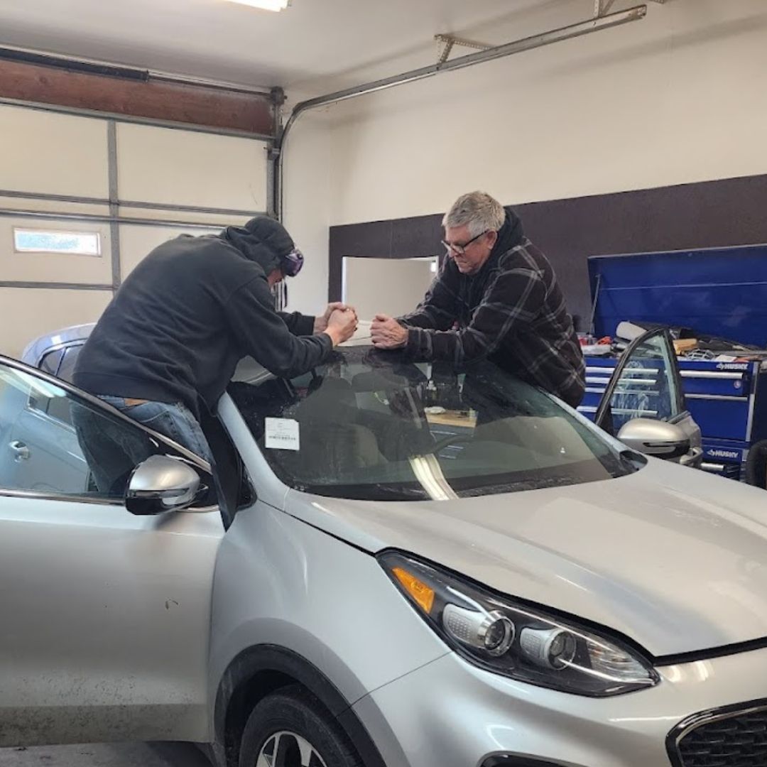 affordable auto glass team of experts working on windshield replacement inside a garage