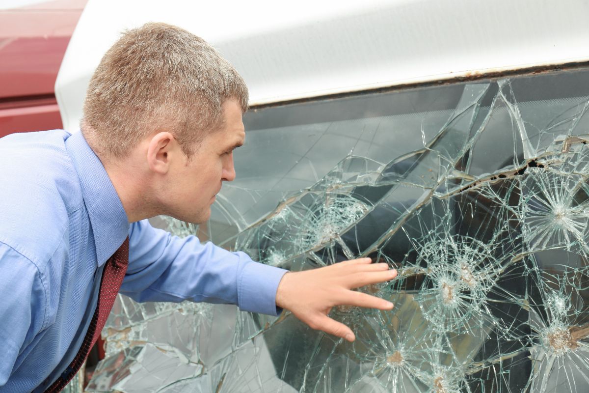 Insurance man checking on broken windshield for replacement. Understanding windshield replacement insurance coverage in Wisconsin