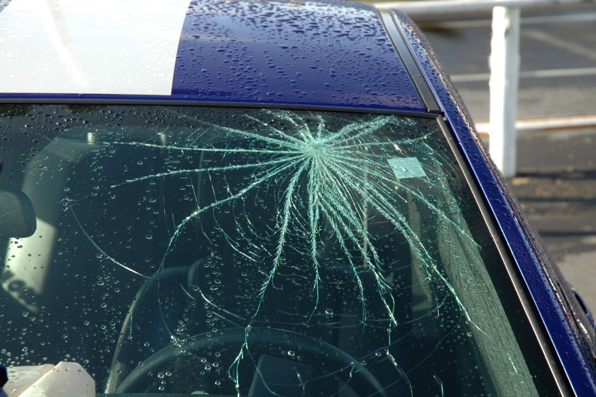 replacing a car windshield under a covered area on a rainy day in Wisconsin