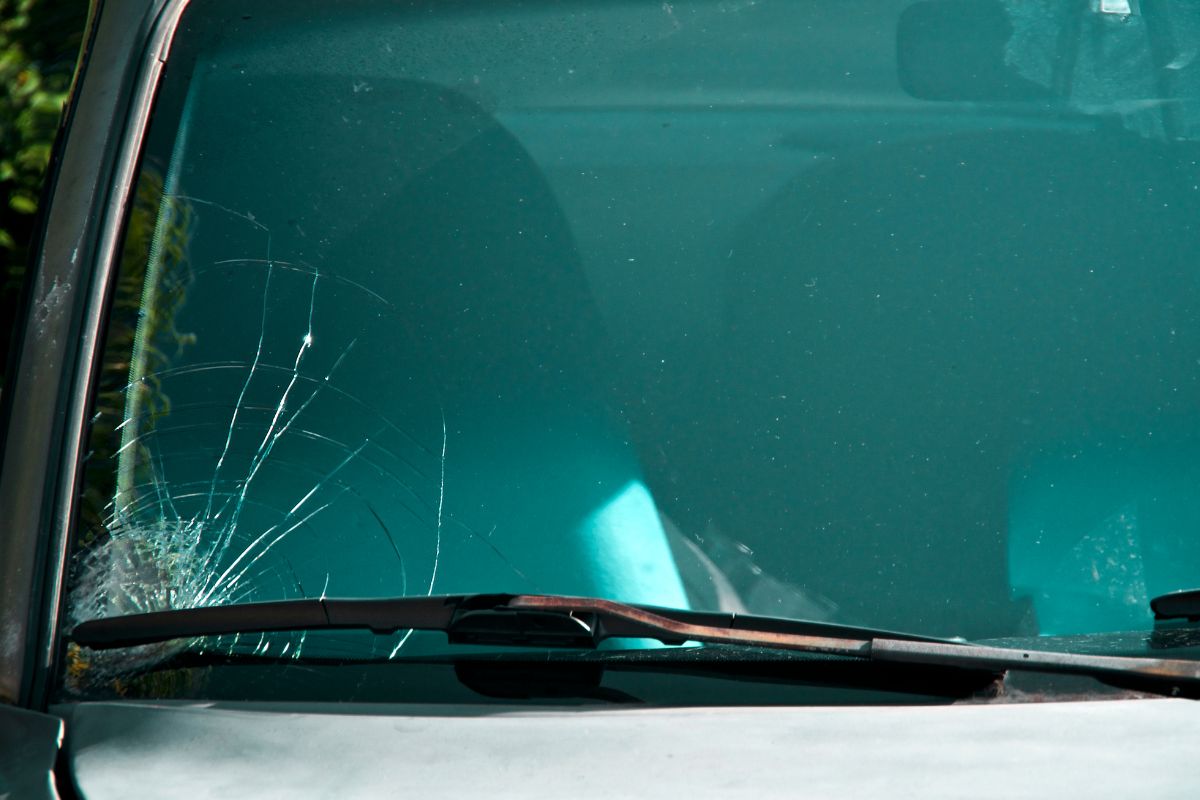 Close-up of a cracked windshield showing a long surface crack, indicating potential need for replacement