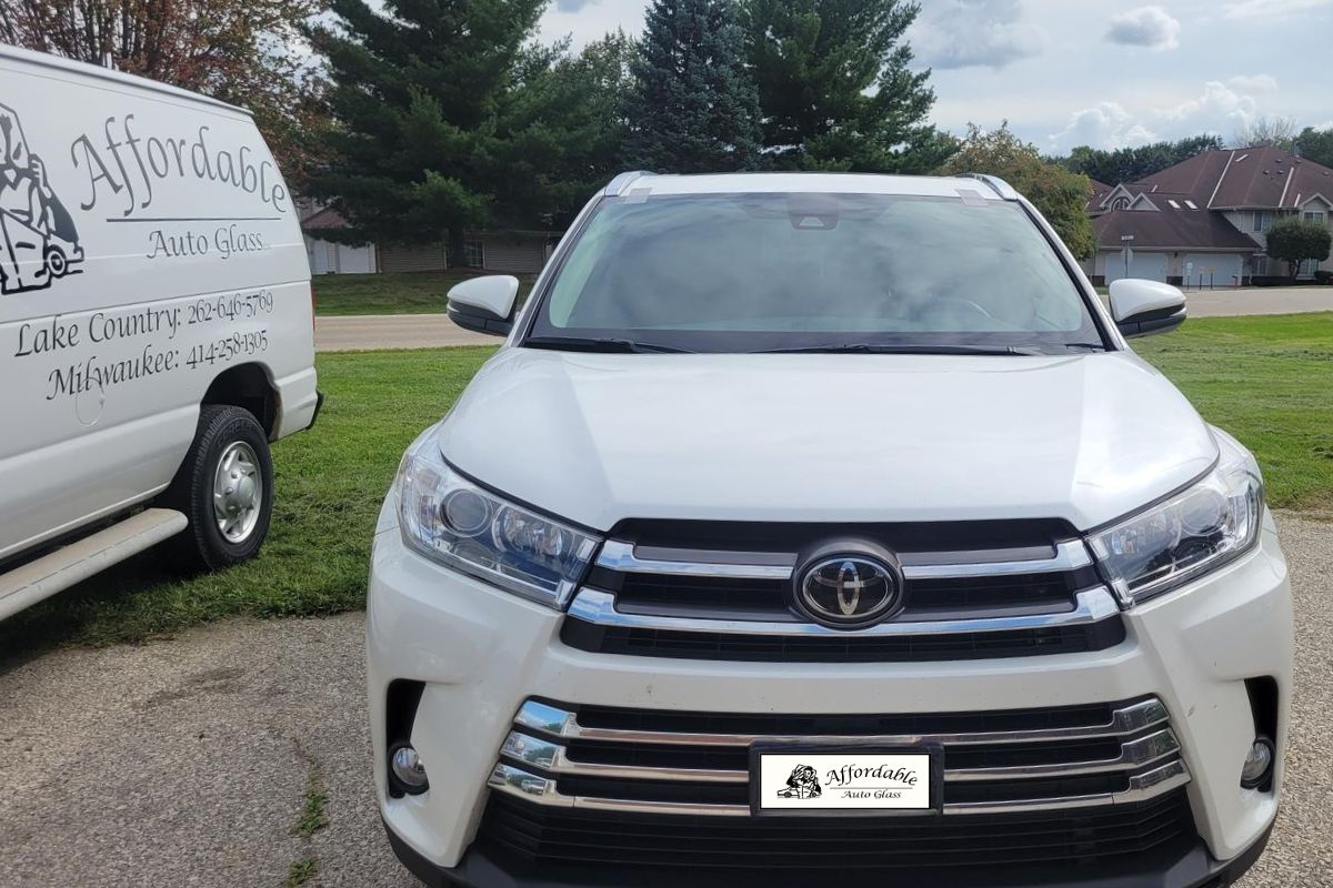 Affordable Auto Glass technician completes a mobile windshield replacement on a white Toyota SUV in Wisconsin, showcasing fast and professional on-site auto glass services near Wauwatosa and Milwaukee.