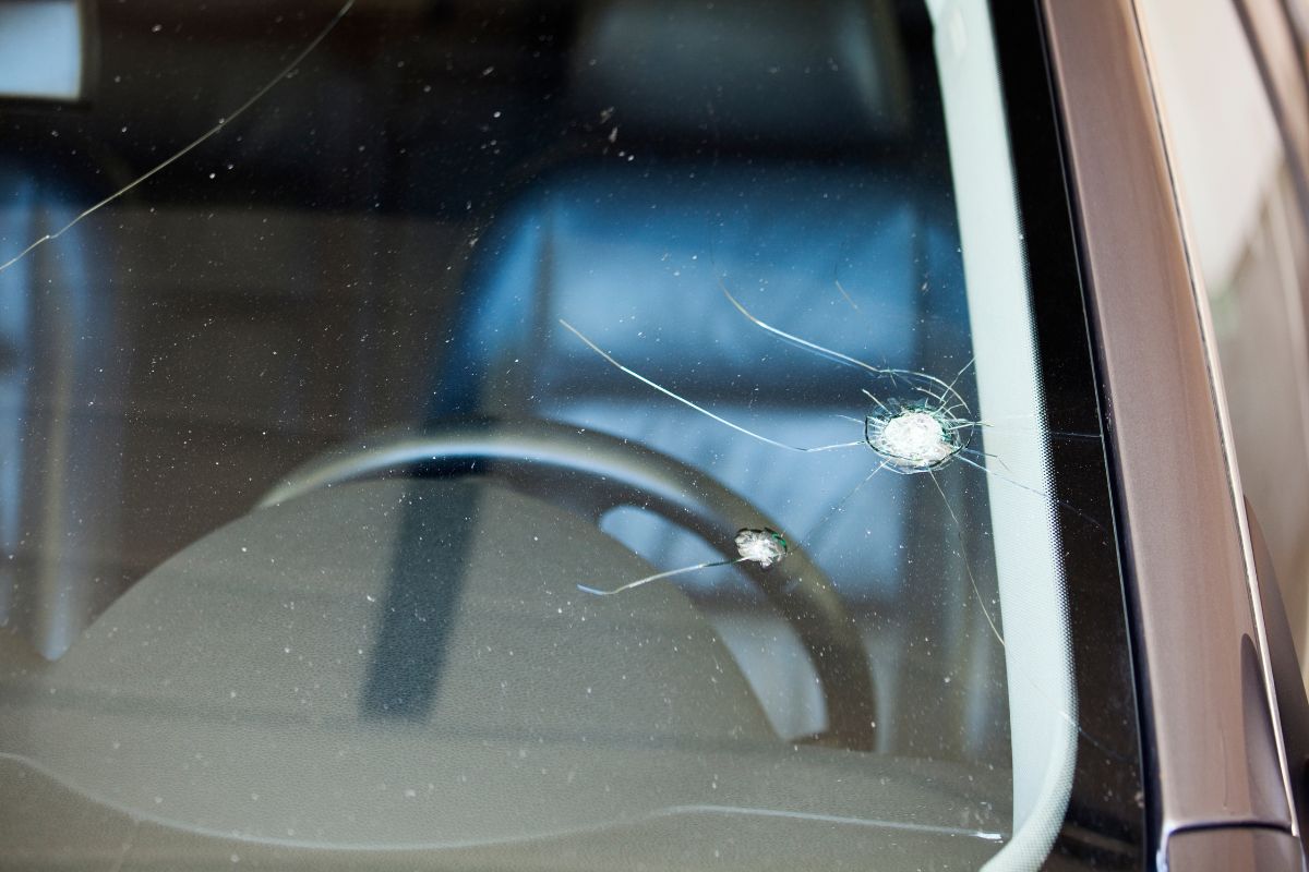 Close-up of a car windshield with multiple visible cracks and rock chip damage, showing the type of auto glass repair handled by Affordable Auto Glass in Wisconsin.