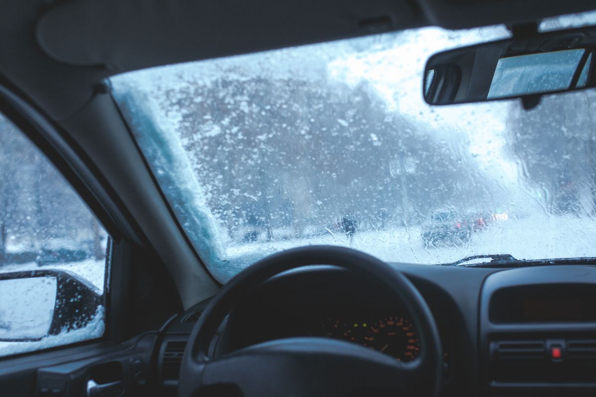 Interior view of a car windshield covered in ice and snow during cold winter weather in Wisconsin.