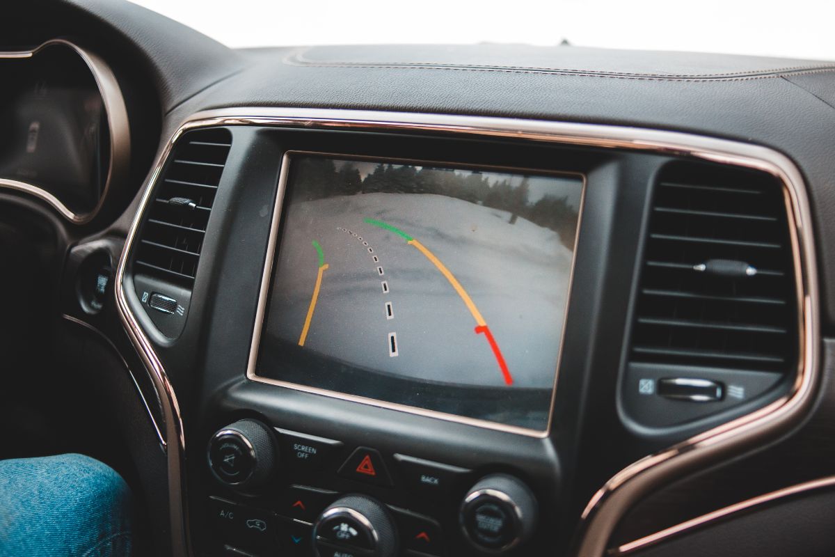 Vehicle dashboard display showing a backup camera with parking guide lines, illustrating how ADAS features rely on proper calibration after windshield replacement.