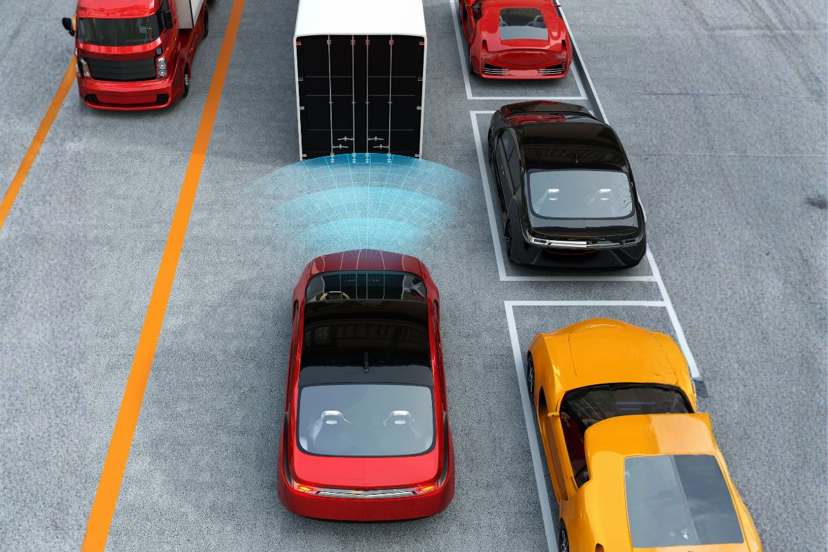 Top view of cars on the road with automatic emergency braking sensor detection shown as a blue radar field behind a vehicle.