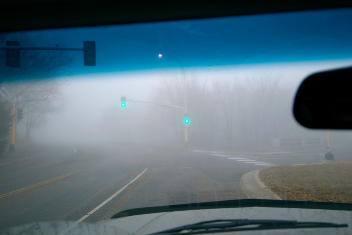 Foggy road view through a damaged windshield before chip and leak repair in Jefferson County, WI