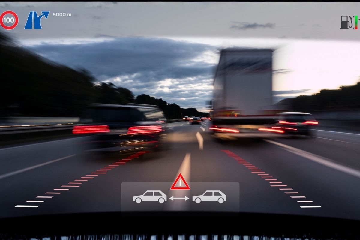 Forward collision warning and ADAS visual alerts displayed on a windshield, showing how mobile ADAS calibration helps maintain accurate safety system detection after auto glass work.